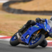 Yamaha R7 azul inclinada em curva em autódromo, com piloto em posição esportiva